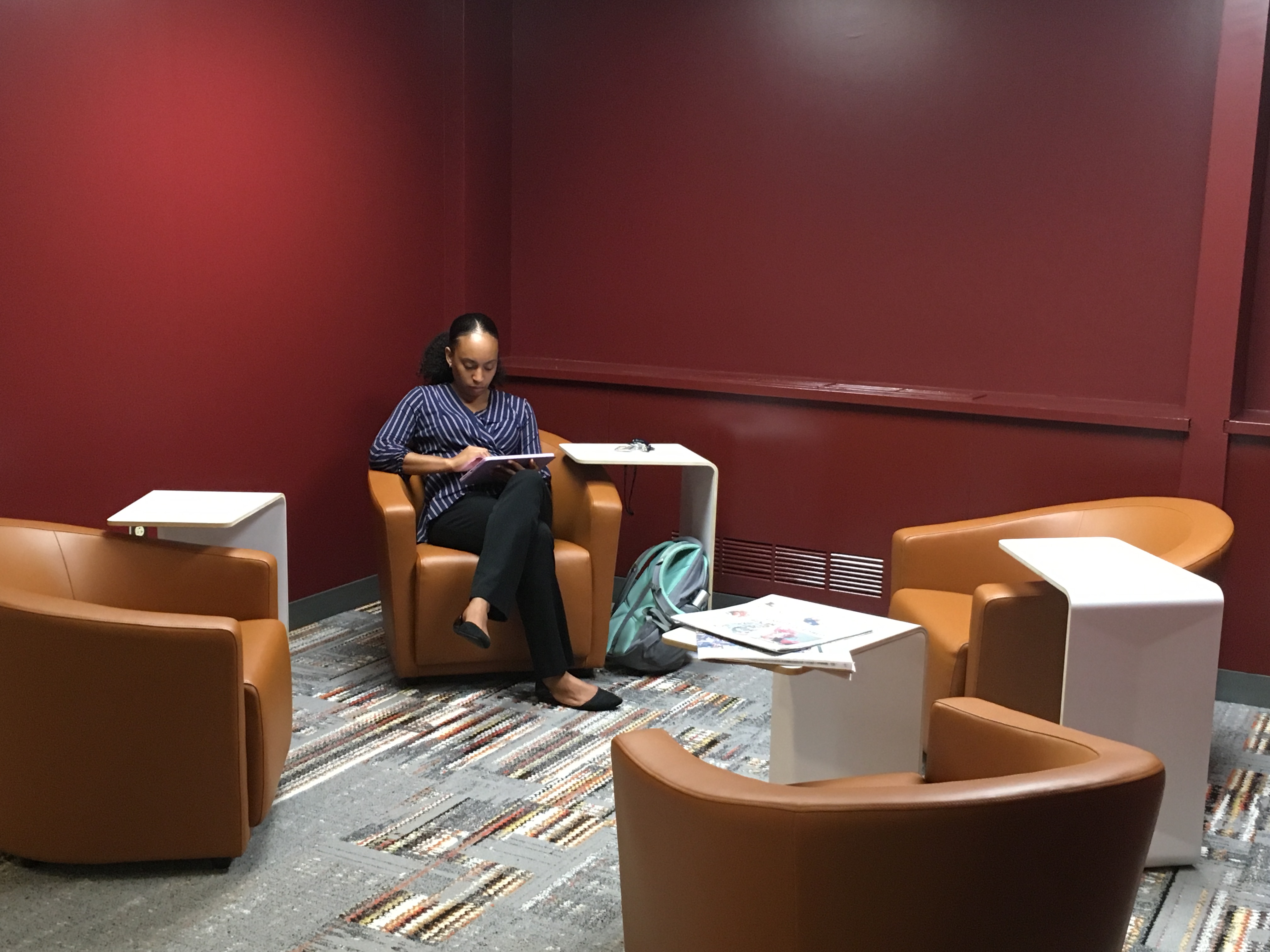A women sits in a chair in the Queen Lane Library lobby